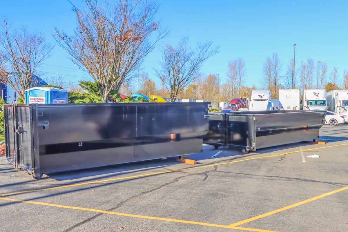 Professional dumpster rental service with roll-off container on residential driveway in Lanett